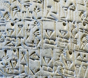 Placa de argila clara com escrita cuneiforme