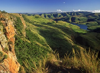 Foto de uma paisagem com montanhas, cobertas por vegetação e árvores