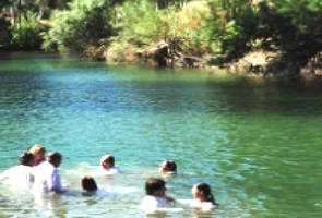 Batismo cristão sendo realizado nas águas do rio Jordão