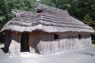 Foto de uma casa ainu feita de madeira e coberta com fibras vegetais