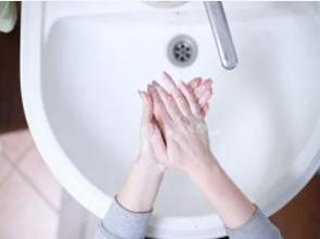 Mãos humanas lavanda as mãos numa pia.