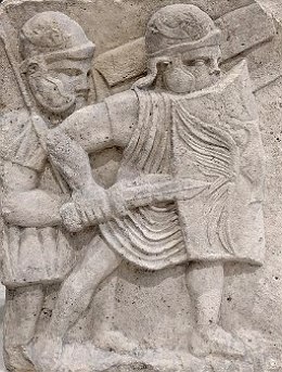 Relevo em parede mostrando dois soldados com escudo e espada