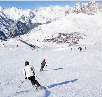 Esquiadores descendo uma montanha com neve