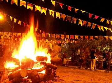 Foto mostrando a fogueira da festa junina num local com bandeirinhas