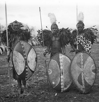 Foto antigo mostrando guerreiros massai com lan&ccedil;as e escudos