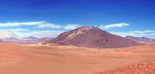 Foto mostrando um deserto com uma montanha ao fundo