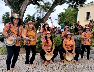 Mulheres tocando o carimb&oacute; com seus instrumentos musiciais