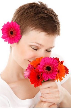 Mulher cheirando flores