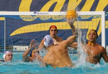 Partida de Polo Aqu&aacute;tico com jogador preparando o jogar a bola no gol.