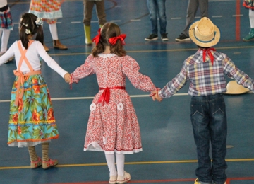Crian&ccedil;as dan&ccedil;ando a quadrilha numa Festa Junina