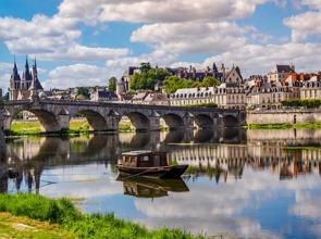 Rio Loire na França com ponte, barco e casas.