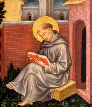 São Tomás de Aquino, retratado como santo, sentado numa espécie de caixa e lendo um livro